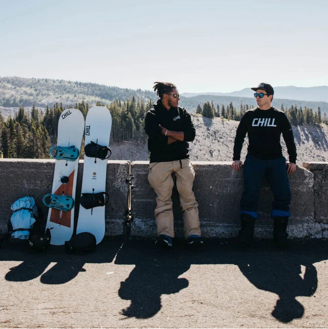 Two men standing next to snowboards