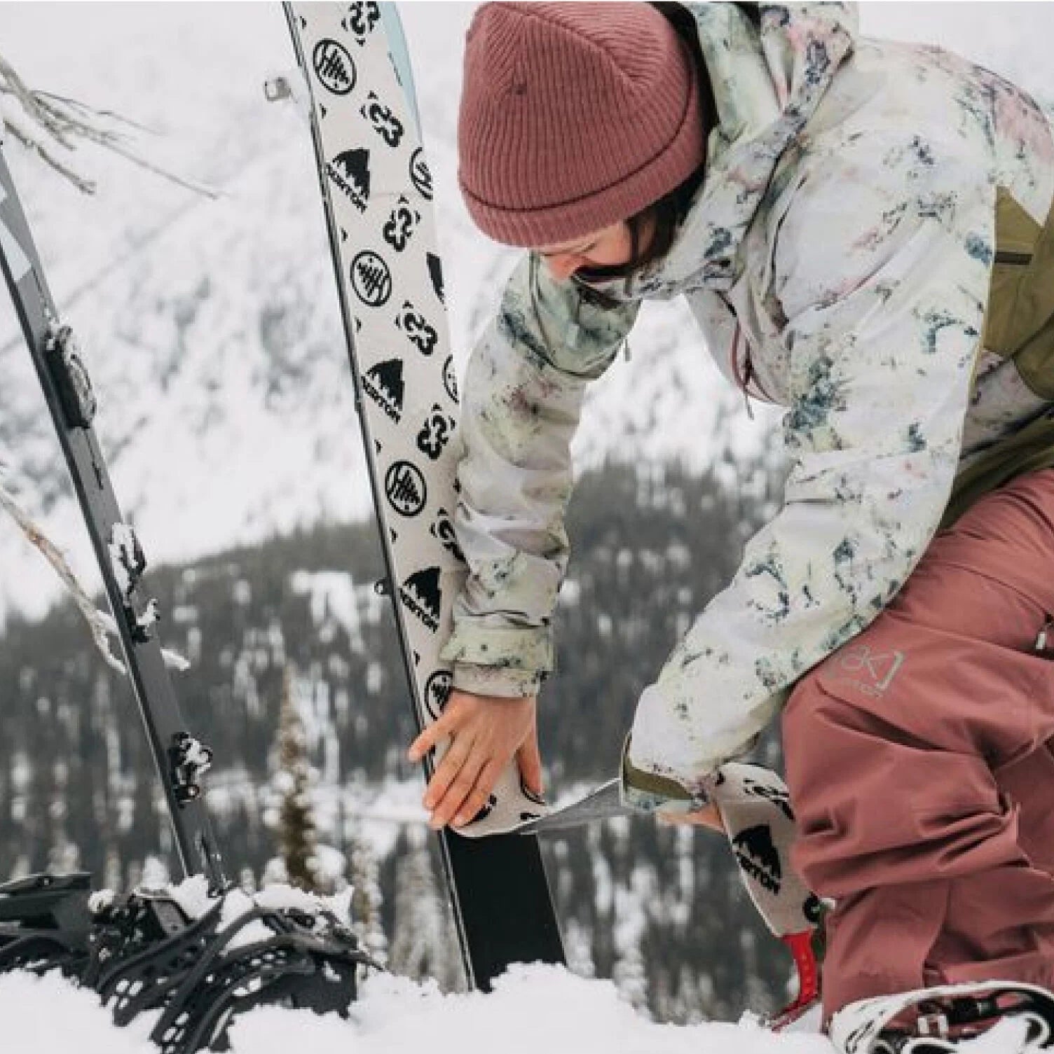 Splitboarder applying skins to board