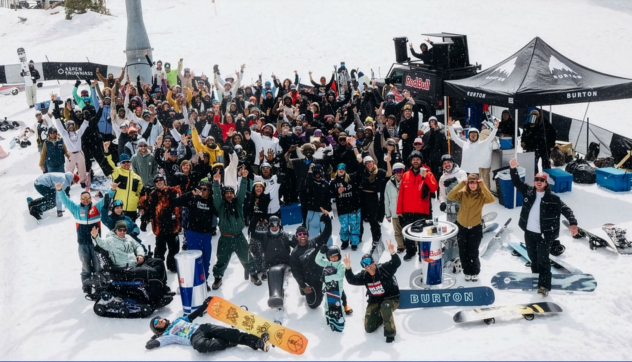 Large group of snowboarders gathered at the base for a photo