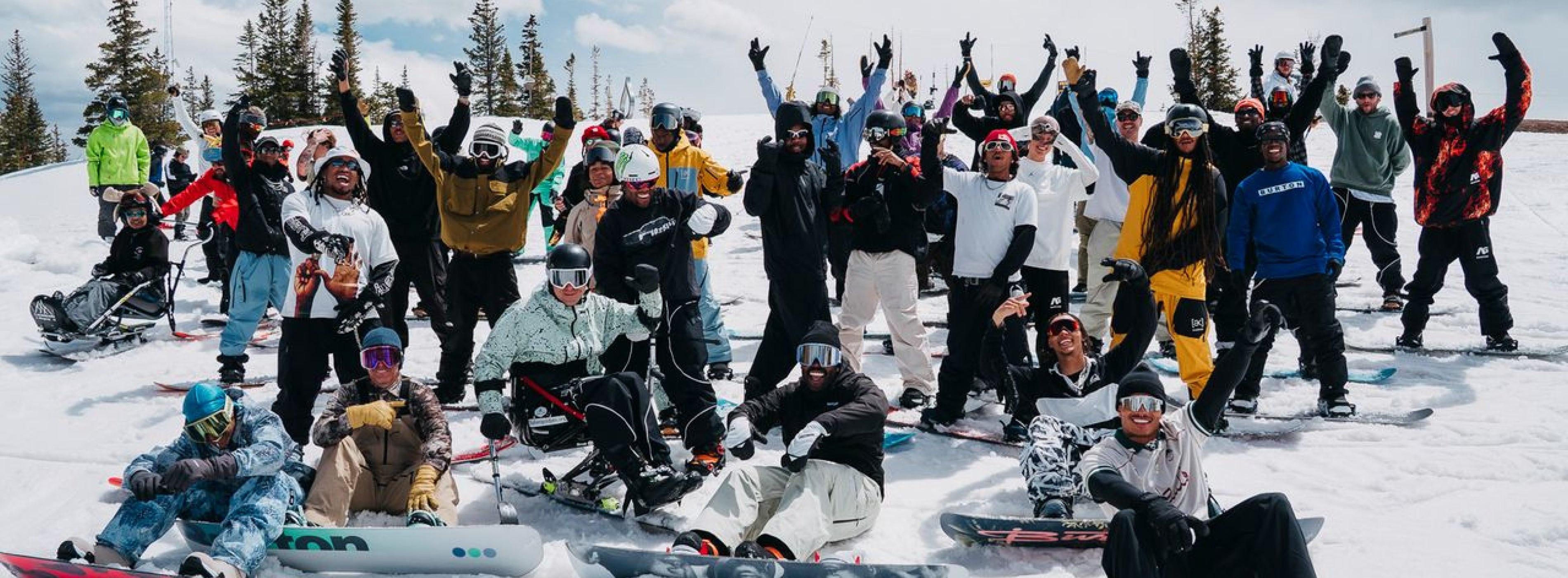 A large group of snowboarders posing for a photo
