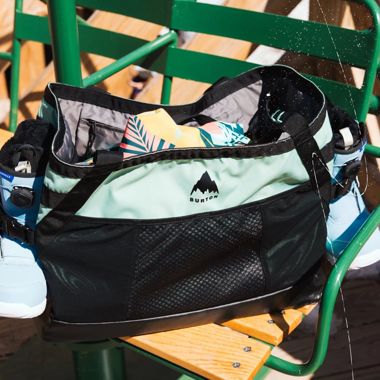 Black and green bag with a visible brand logo on a green chair.