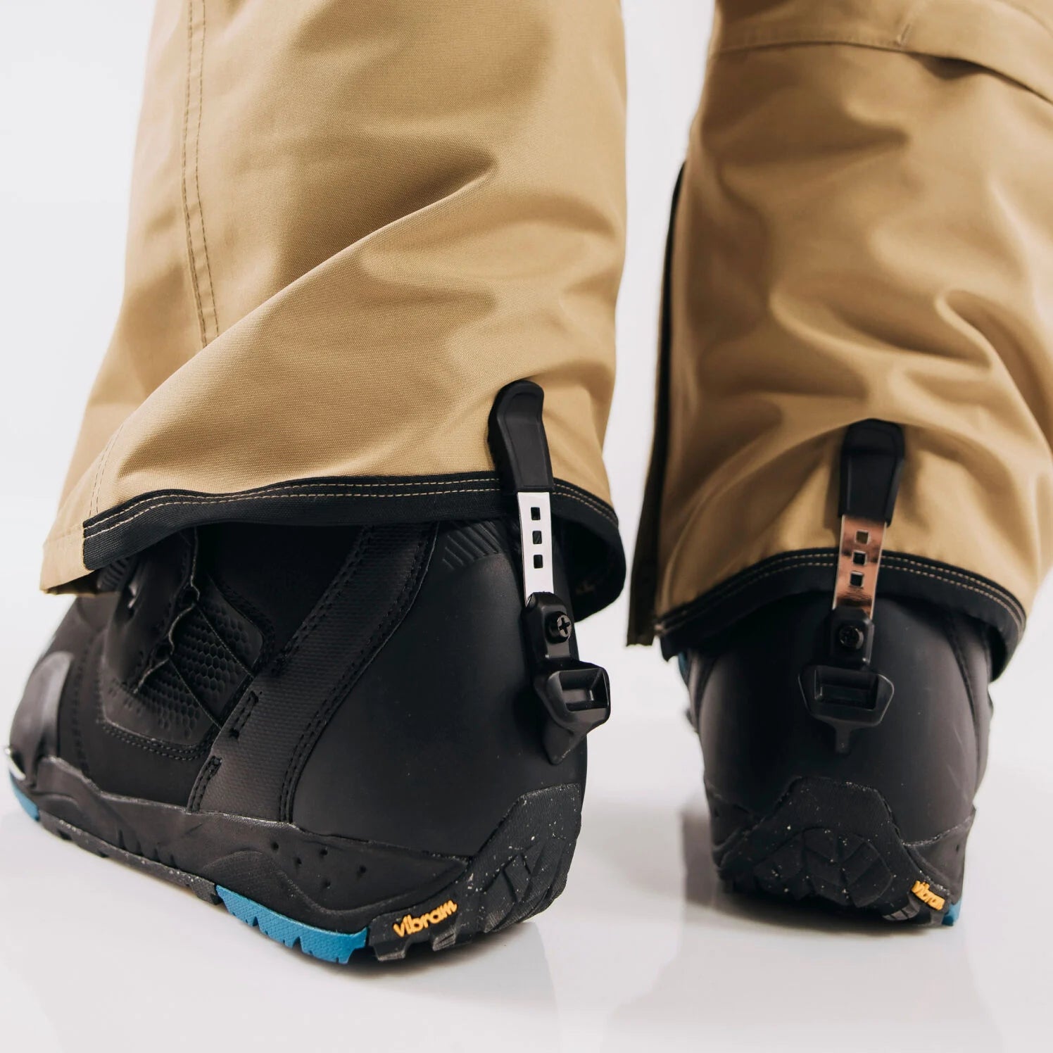 Close-up of cuff clip on Step On boots with beige pants on a white background