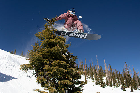 Person on Mine77 board ollie's over a tree