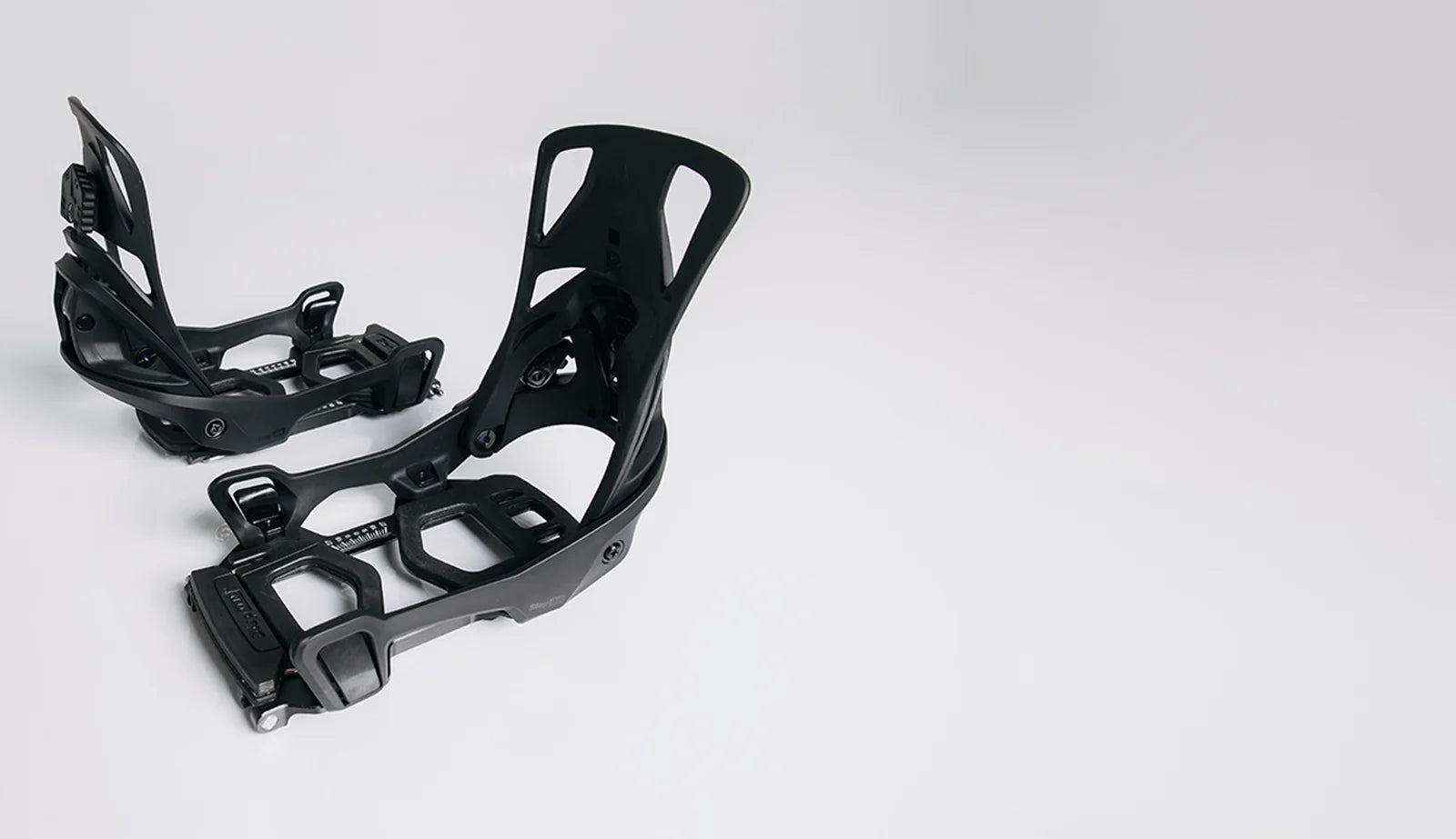 Black snowboard bindings on a white background