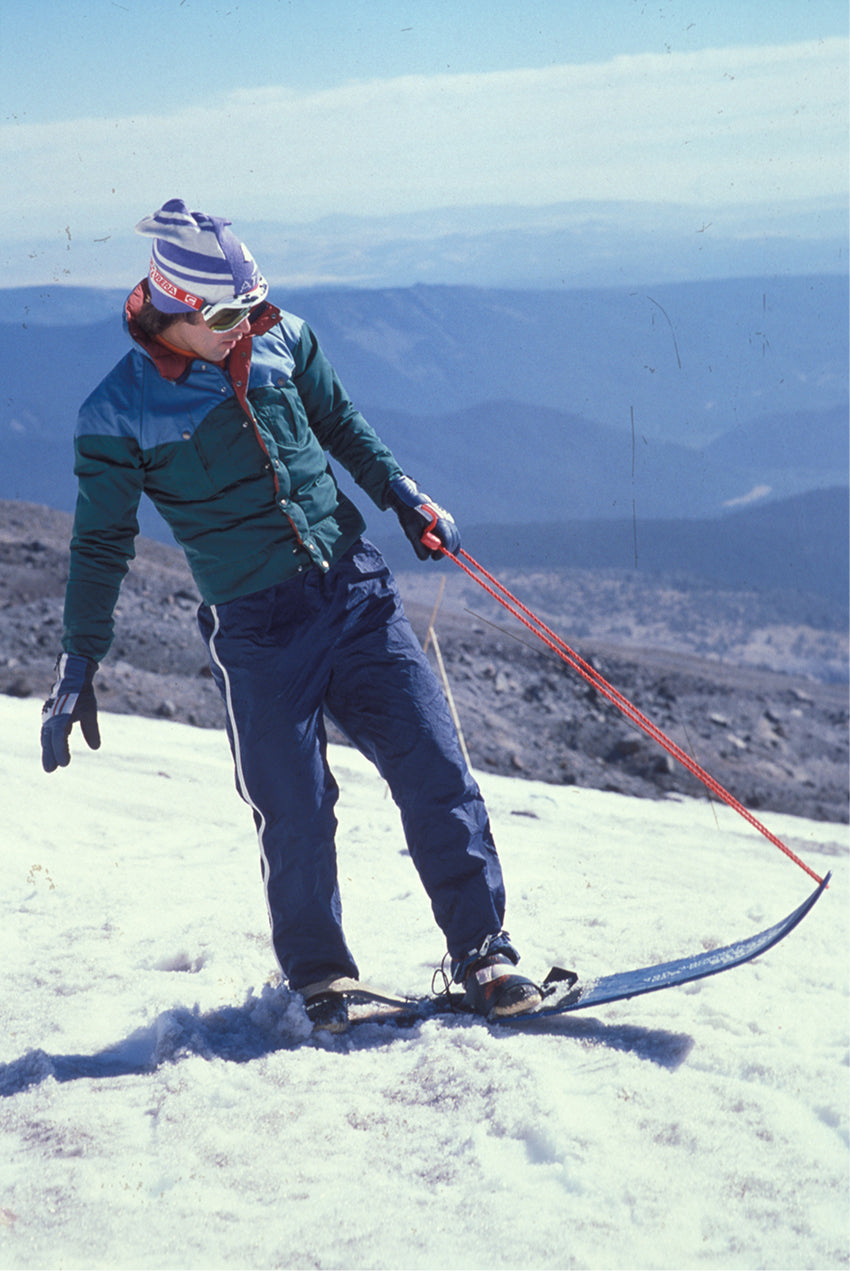A historic image of Jake Burton snowboarding in the late 1970s