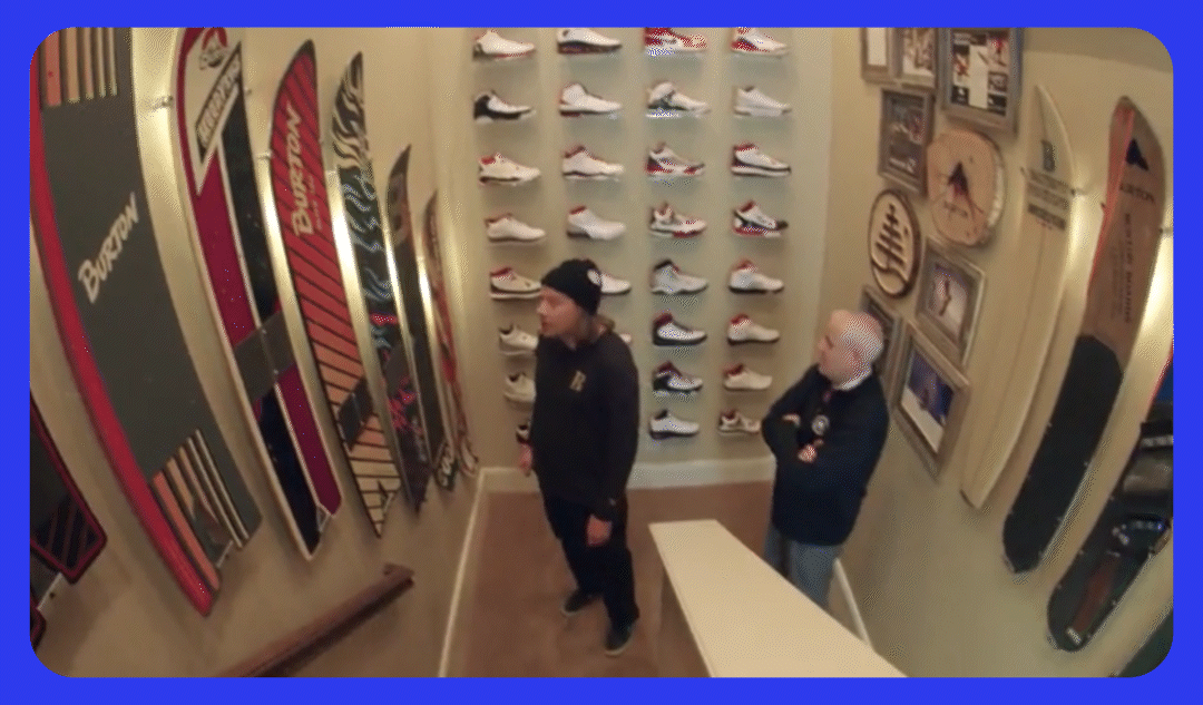 TK admiring a snowboard collector's snowboard collection in the stairwell of their home.