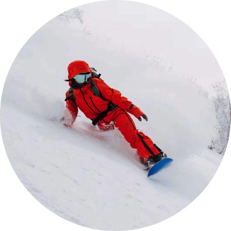 Person snowboarding in red gear on a snowy slope