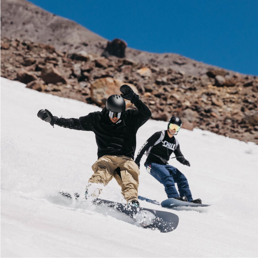 Two people riding snowboards