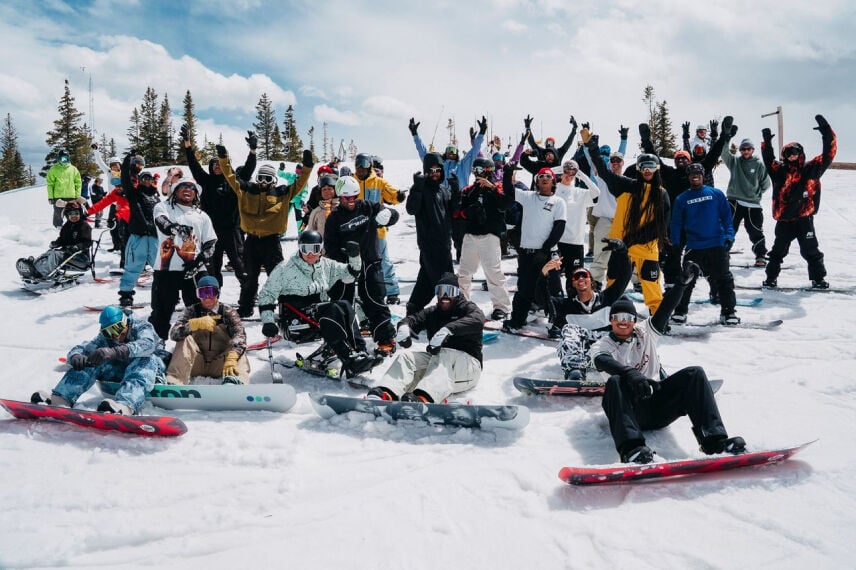 A large group of snowboarders posing for a photo