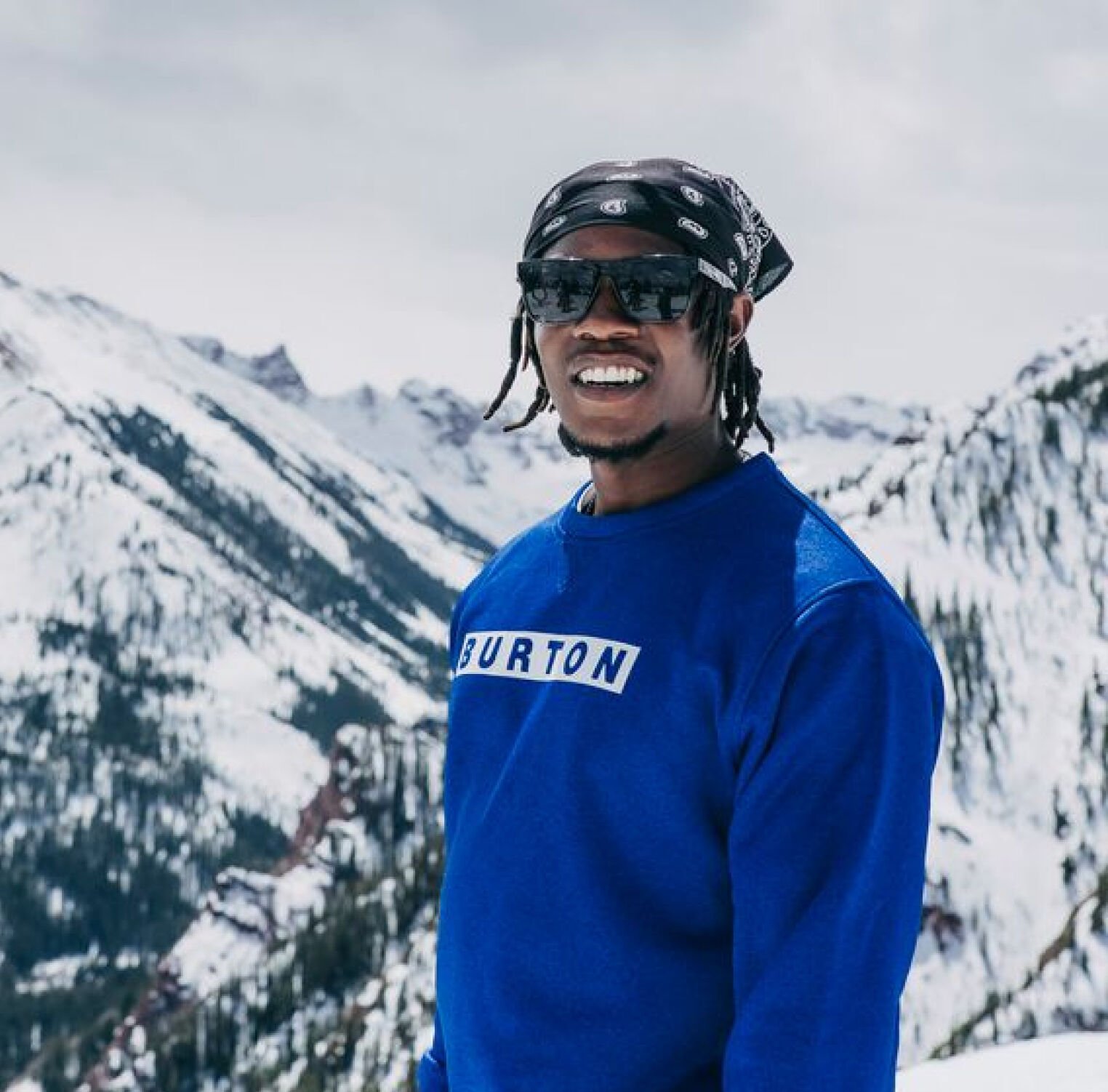 A person wearing a Burton sweatshirt standing on top of a mountain