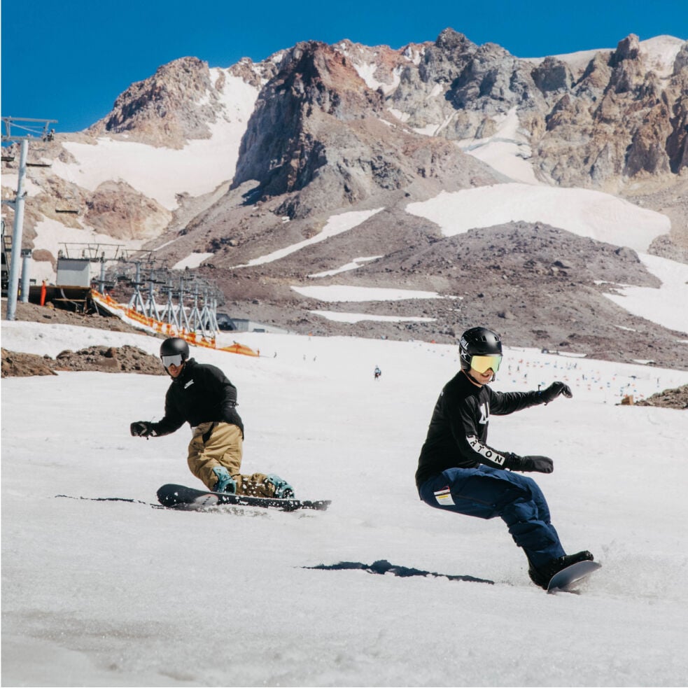 Deux personnes ridant un snowboard